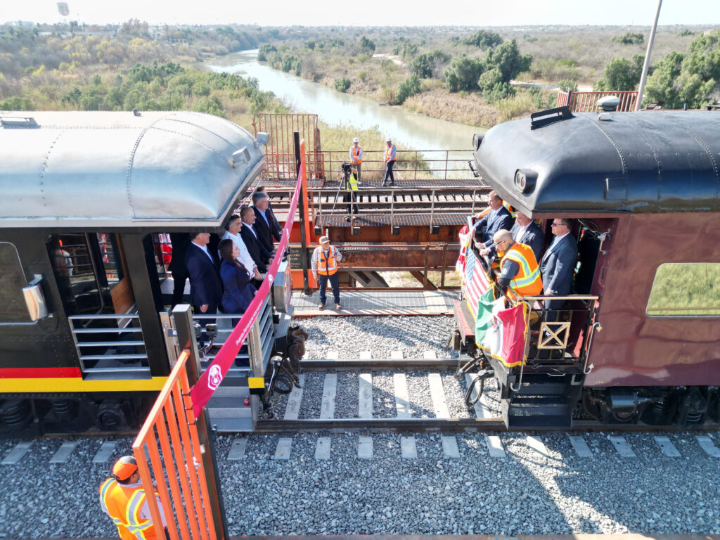 En un acontecimiento histórico que reafirma el liderazgo de Nuevo Laredo como el epicentro del comercio mundial, este jueves se llevó a cabo la inauguración del Segundo Puente Ferroviario Internacional que conecta a esta ciudad tamaulipeca con Laredo, Texas, y con el que se duplicará la capacidad de cruces diarios. Este logro, resultado de una inversión privada superior a los 100 millones de dólares por parte de Canadian Pacific Kansas City (CPKC), consolida los lazos comerciales y de hermandad entre México, Estados Unidos y Canadá; además, coloca a esta ciudad fronteriza como la única en México en contar con dos cruces internacionales para ferrocarril. Jesús Antonio Esteva Medina, secretario de Infraestructura, Comunicaciones y Transportes (SICT) y representante de la presidenta de México, Claudia Sheinbaum Pardo; el gobernador de Tamaulipas, Américo Villarreal Anaya; y la alcaldesa de Nuevo Laredo, Carmen Lilia Canturosas Villarreal, junto a Oscar Del Cueto, presidente y representante ejecutivo de CPKC de México, encabezaron la ceremonia, destacando la importancia de esta infraestructura para fortalecer el comercio transfronterizo y la economía regional. Esteva Medina destacó el gran impulso que la presidenta Sheinbaum Pardo ha dado a este tipo de proyectos que fortalecen la economía del país y que son clave para generar las condiciones propicias de crecimiento, progreso y bienestar para los mexicanos. “Ya lo dijo nuestra presidenta: esta inauguración es de gran relevancia por su importancia comercial y el simbolismo que tiene; este puente es un símbolo económico y de la importancia del tratado comercial de los tres países. Gracias a este puente se tendrá la posibilidad de transportar mercancías de una manera más rápida, eficiente y segura desde el centro de México hasta Canadá”, enfatizó. El gobernador resaltó el liderazgo de la presidenta Claudia Sheinbaum Pardo para llevar a cabo las negociaciones con el Gobierno de Estados Unidos y hacer respetar la soberanía de México, fortaleciendo así la relación comercial entre ambos países, de la cual Nuevo Laredo es un pilar. “Tenemos aquí en Nuevo Laredo una punta de desarrollo importante a nivel nacional y, desde nuestra entidad, tres eventos que marcan economías de escala: la autorización para construir el segundo cuerpo y ampliación del Puente del Comercio Mundial, con el apoyo del Gobierno Federal; hoy tenemos la Agencia Nacional de Aduanas de México (ANAM) y ahora un segundo puente ferroviario internacional”, señaló el gobernador. Por su parte, la presidenta municipal resaltó que, gracias a la inversión en obra pública que han realizado los Gobiernos Estatal y Municipal en la ciudad, se han impulsado importantes proyectos estratégicos, como la construcción del segundo cuerpo y puente de la carretera Mex 2, que abona al dinamismo comercial de la frontera. Reiteró su compromiso de continuar priorizando la inversión en infraestructura con un enfoque social y de desarrollo económico que potencialice las ventajas competitivas de Nuevo Laredo. “Que este puente sea un testimonio duradero de nuestras acciones conjuntas para fortalecer el comercio internacional y la cooperación transfronteriza, y un faro de esperanza para un futuro de prosperidad compartida. A todos los presentes, gracias por ser parte de este momento trascendental. Bienvenidos a Nuevo Laredo, donde el pasado y el futuro se encuentran para forjar un camino de oportunidades y crecimiento sin igual”, señaló. Oscar Augusto Del Cueto Cuevas, presidente y representante ejecutivo de CPKC en México, hizo énfasis en la importancia de la frontera de los Dos Laredos para duplicar su capacidad de transporte de mercancías a través de lo que consideró como el puente de entrada más grande de Norteamérica. “Este día marca un hito en la historia de Nuevo Laredo. Después de 19 meses, el puente ferroviario internacional inicia hoy un camino siendo el único punto fronterizo con dos puentes. Nuevo Laredo ha sido también, históricamente, un punto estratégico para el comercio internacional y, con esta nueva infraestructura, damos un paso firme hacia la modernización de nuestras cadenas de suministro”, señaló. Este nuevo puente ferroviario permitirá una conexión más eficiente entre los mercados de México, Estados Unidos y Canadá. La empresa ferroviaria CPKC subrayó las ventajas únicas de su servicio de línea única, que se extiende por más de 32,000 kilómetros de vías a lo largo de América del Norte, impulsado por un equipo de más de 20,000 trabajadores dedicados al ferrocarril. Durante los últimos 27 años, la empresa ha mantenido una sólida relación de colaboración con los gobiernos de México, Tamaulipas y Nuevo Laredo, reafirmando su compromiso con el desarrollo de la región. El nuevo puente ferroviario de segunda vía cuenta con una longitud total de 1,170 pies y ha sido construido con una estructura de vigas de placa con tablero lastrado, apoyado en seis pilas de hormigón armado. Se localiza a 35 pies del puente ya existente, permitiendo la circulación simultánea de trenes en ambas direcciones, lo que agilizará el tráfico ferroviario y reducirá los tiempos de cruce. Además, la infraestructura incluye 4,500 pies de nueva vía y una serie de mejoras en seguridad fronteriza, entre las que destacan un nuevo sistema de inspección de vagones por rayos X y cámaras de vigilancia. Estas inversiones permitirán un tránsito más seguro y eficiente, beneficiando tanto a la industria como a la economía de la región. Con la puesta en marcha de este nuevo puente, Nuevo Laredo reafirma su posición estratégica como el principal punto de comercio entre México y Estados Unidos, consolidándose como una pieza clave en la logística global y el desarrollo económico de Norteamérica. En la inauguración estuvieron presentes Andrés Lajous, titular de la Agencia Reguladora de Transporte Ferroviario; Cameron MacKay, embajador designado de Canadá en México; Erika Sielke, cónsul general de Estados Unidos en Nuevo Laredo; Eduardo Garza, representante del Consejo Coordinador Empresarial, así como senadores, diputados federales y locales.